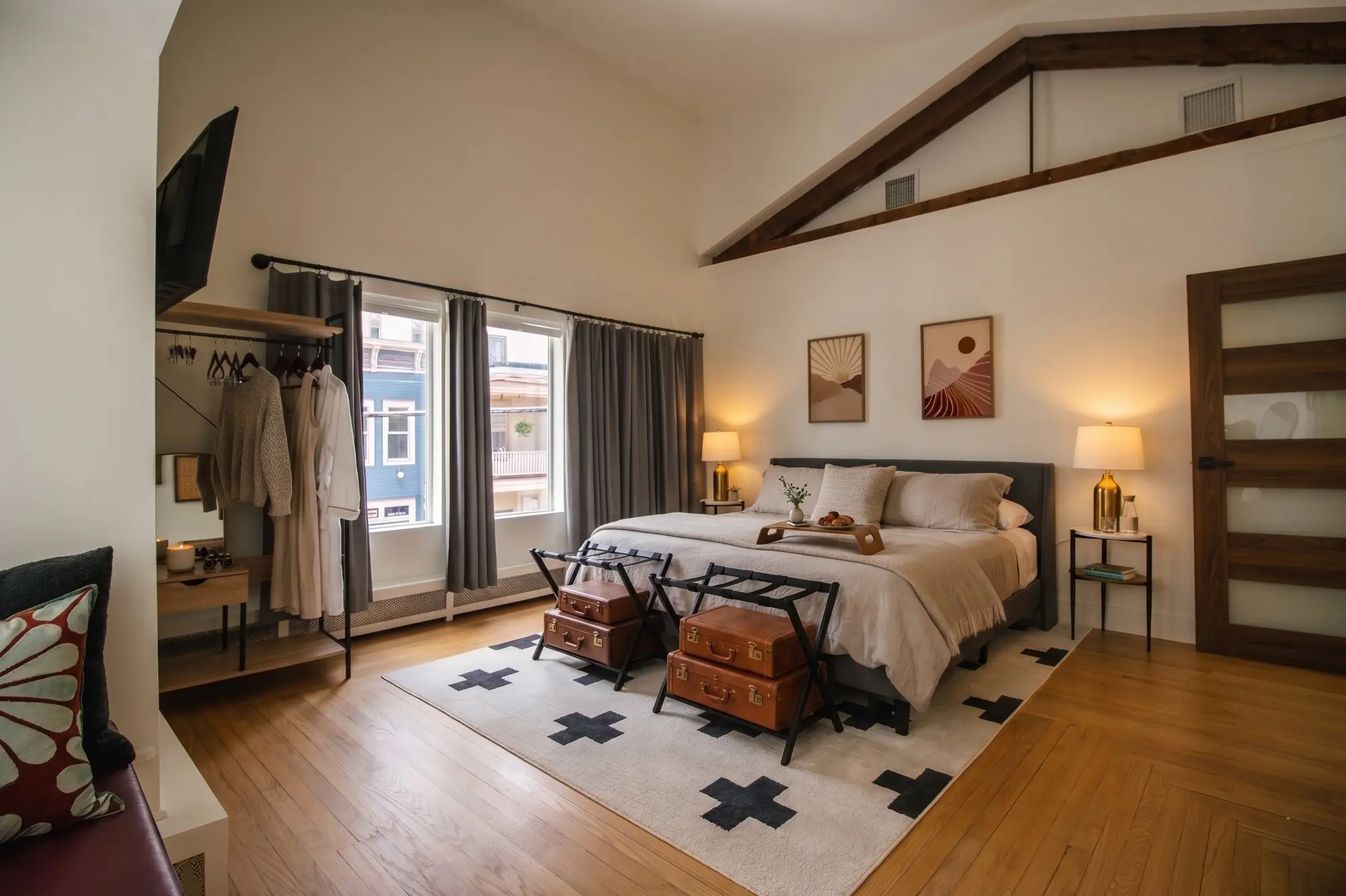 Spacious King bedroom at River Penthouse with vaulted ceiling, exposed beam, and Main Street window view, Narrowsburg NY