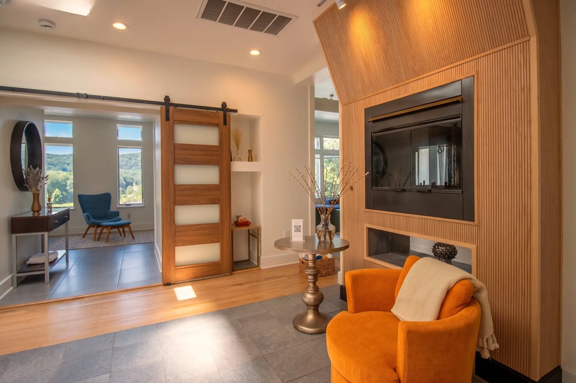 River Penthouse fireplace and lounge area with orange armchair, Narrowsburg NY