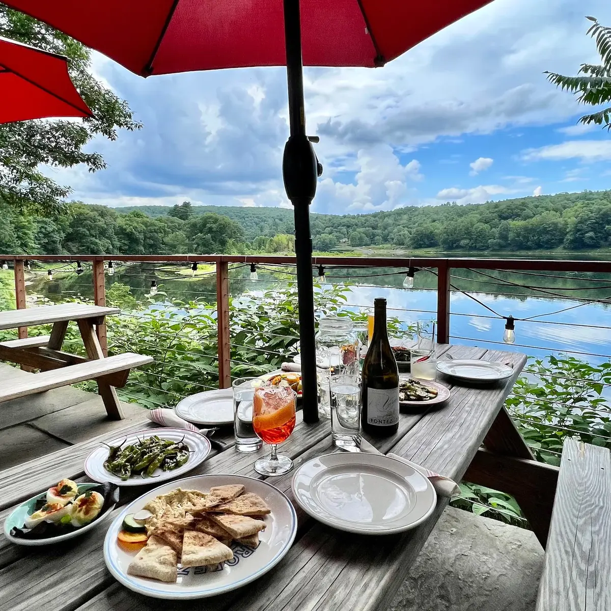 Tablescape on The Laundrette's porch with Delaware River views — Narrowsburg NY wood-fired pizza and wine bar